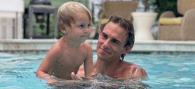 Tyler Thompson smiling in the pool with his young son after a leak repair