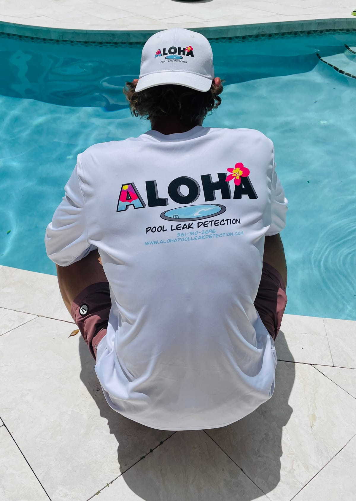 Tyler Thompson poolside in his Aloha Pool Leak Detection shirt and cap